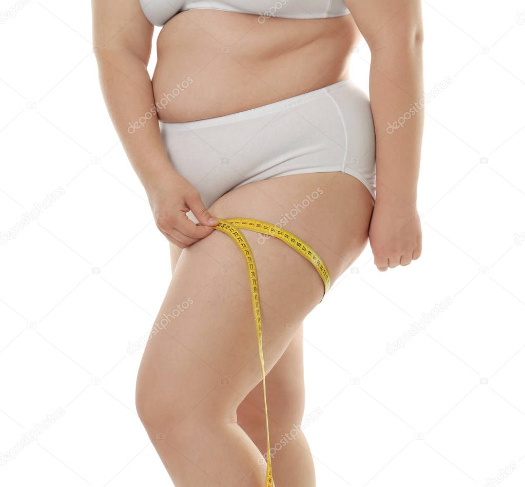 Overweight woman measuring thigh 