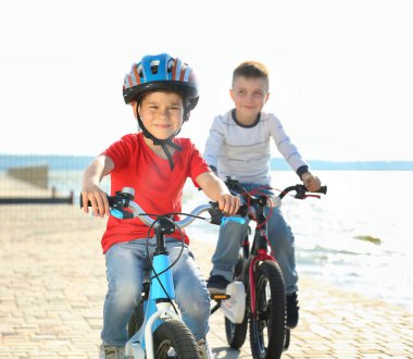 Sevimli küçük çocuklar güneşli günde Nehri yakınında bisiklet sürme