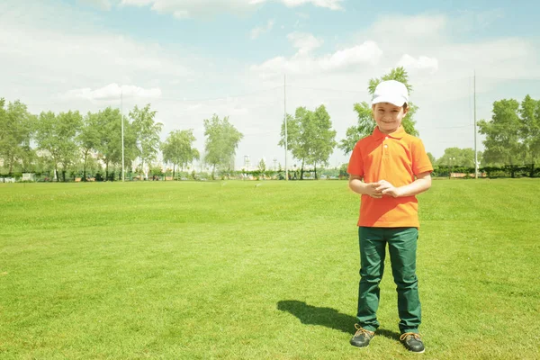 Мальчик стоит на поле для гольфа — стоковое фото