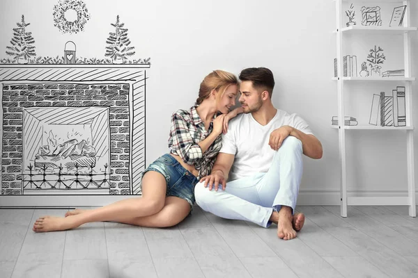 Young couple thinking about Christmas and New Year decorations of flat