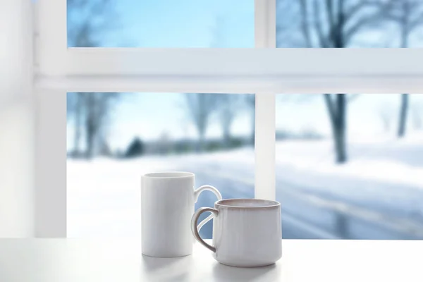 Cups of aromatic tea on windowsill — Stock Photo, Image