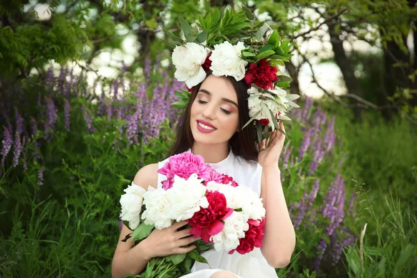 Giovane donna con bouquet di peonie — Foto Stock