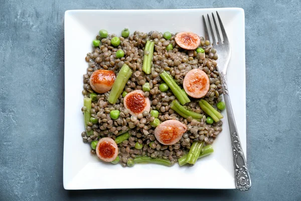 Piatto con gustoso porridge di lenticchie, salsicce e verdure — Foto Stock