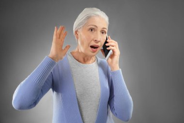 Cep telefonuyla konuşan yaşlı kadın. 