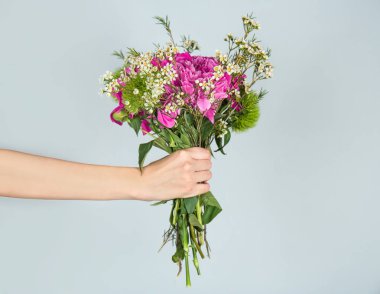 el çiçekleri tutarak 