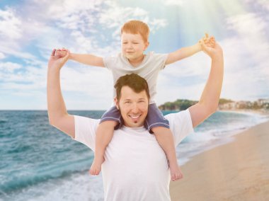 Babası ile küçük oğlu deniz kıyısında oynuyor. Aile tatil kavramı