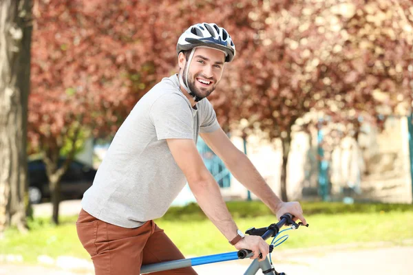 Joven guapo montando en bicicleta al aire libre en un día soleado — Foto de Stock