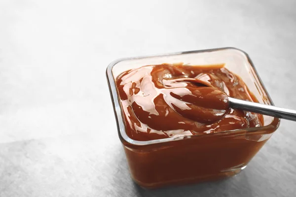 Glass bowl with tasty caramel sauce — Stock Photo, Image