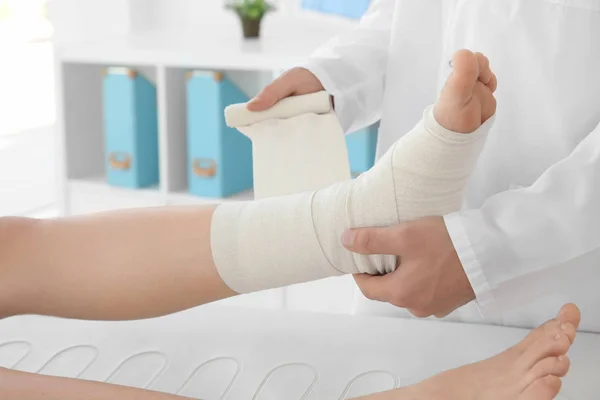 Médecin appliquant bandage — Photo