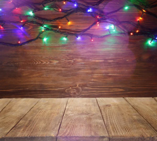 Деревянный стол и рождественские огни — стоковое фото