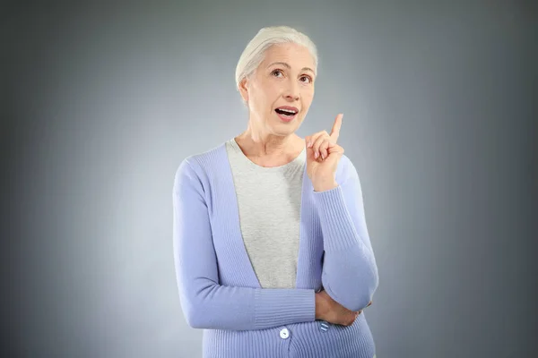 Starší žena ukazuje prstem — Stock fotografie