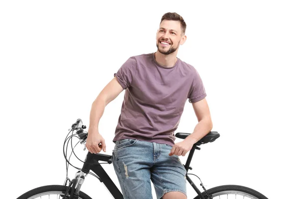 Bonito jovem com bicicleta no fundo branco — Fotografia de Stock