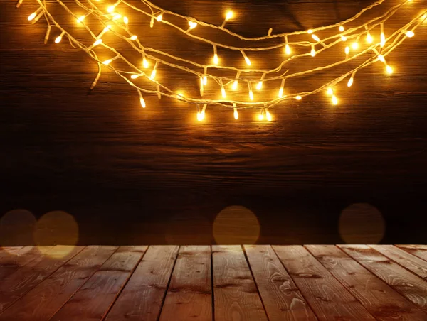 Mesa de madeira e luzes de Natal — Fotografia de Stock