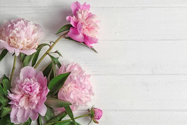 Mooie pioenroos bloemen op lichte houten achtergrond — Stockfoto