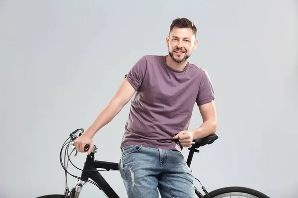 明るい背景に自転車でハンサムな若い男 — ストック写真