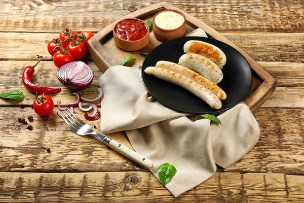 Composição com deliciosas salsichas grelhadas na mesa de madeira — Fotografia de Stock