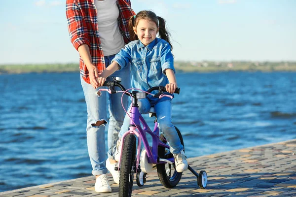 Vrouw onderwijs dochter op de fiets — Stockfoto