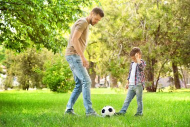 Baba oğul futbol oynuyor.  