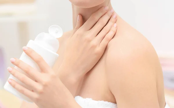 Mujer joven con botella de cosmético —  Fotos de Stock