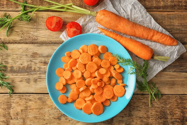 Blue plate with cuts of carrot — Stock Photo, Image