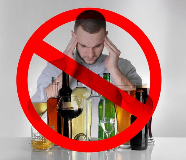 Коллаж алкогольных напитков в стеклянной посуде, молодой человек с головной болью и табличкой "Стоп" на сером фоне — стоковое фото