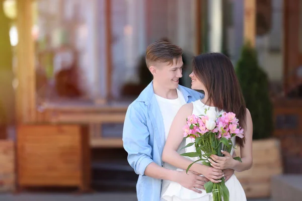 Schönes junges Paar mit Blumenstrauß — Stockfoto