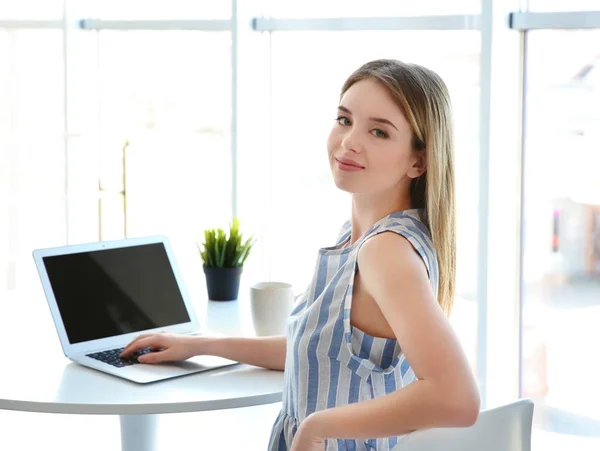 Fiatal lány dolgozik laptop világos szobában — Stock Fotó