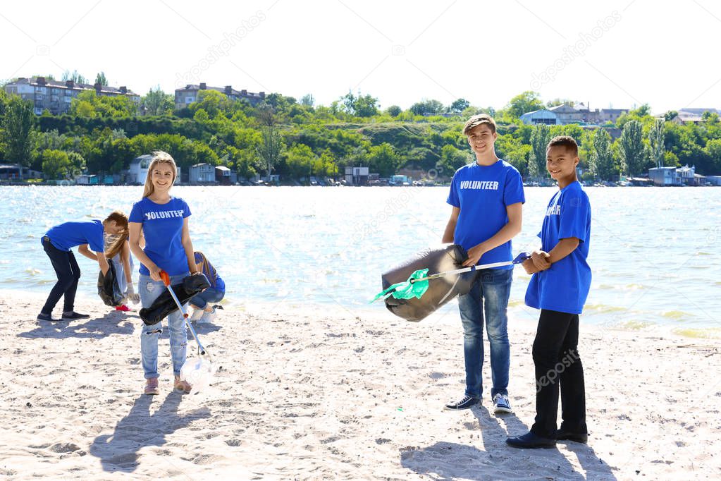 Group of young people cleaning beach area. Volunteer concept