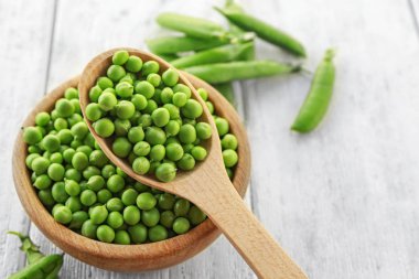 Kase ve kaşık taze yeşil bezelye ile 