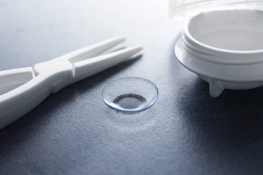Kontakt lens, cımbız ve plastik konteyner 