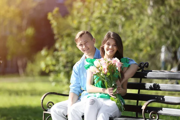 Schönes junges Paar mit Blumenstrauß — Stockfoto