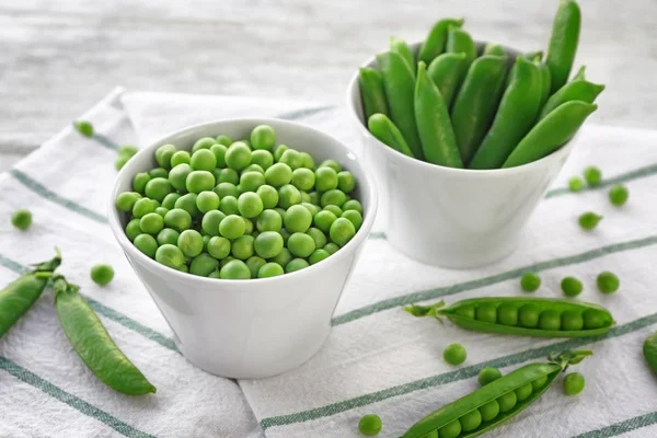 Schalen mit frischen grünen Erbsen — Stockfoto