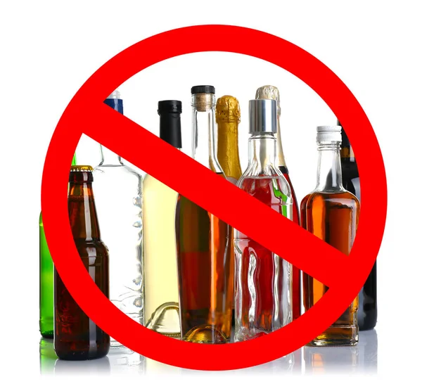 Diferentes bebidas alcoólicas em garrafas com sinal STOP no fundo branco — Fotografia de Stock