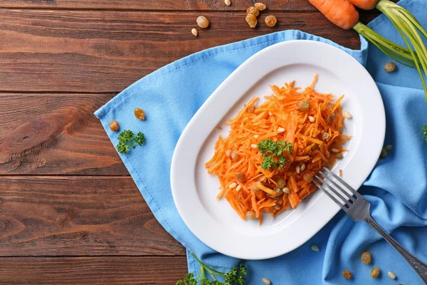Белая тарелка с морковным салатом с изюмом — стоковое фото