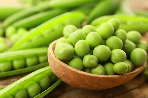 Cuchara de madera con guisantes verdes frescos —  Fotos de Stock