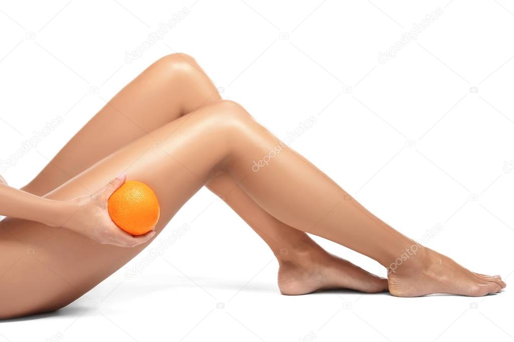 Female legs and orange on white