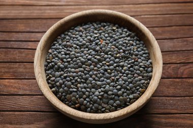 Ahşap arka planda siyah mercimek kasesi