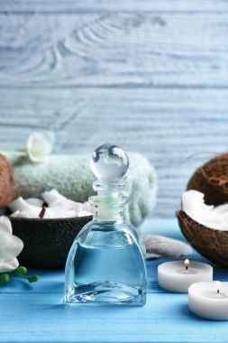 Şişe ahşap arka plan üzerinde kaplıca tedavisi için Hindistan cevizi yağı ile kompozisyon
