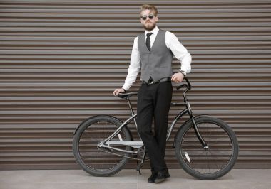 Renk duvar arka plan üzerinde bisiklet ile genç adam