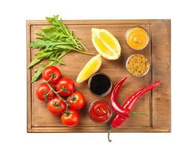 Ahşap plaka farklı sos ve beyaz arka plan üzerinde sebze ile