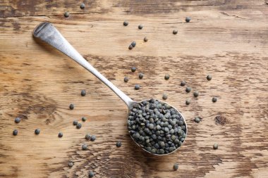 Grunge arka plan üzerinde siyah mercimek kaşıkla