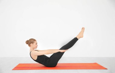 Yoga poz beyaz duvar kapalı yakınındaki pratik genç güzel kadın