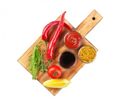 Farklı sos ve beyaz arka plan üzerinde sebze ile ahşap tahta