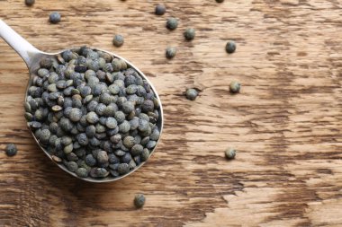 Grunge arka plan üzerinde siyah mercimek kaşıkla