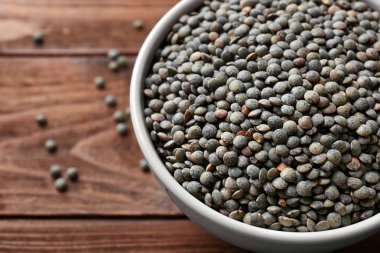 Ahşap arka planda siyah mercimek kasesi