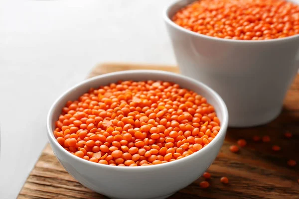 Bowls of red lentils on board — Stock Photo, Image