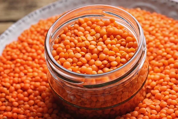 Jar with red lentils on plate, closeup — Stock Photo, Image