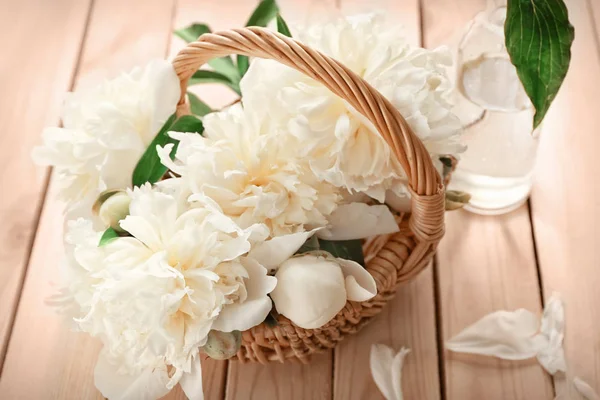 Cesta de mimbre con hermosas flores de peonía en la mesa —  Fotos de Stock