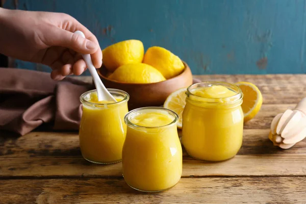 Pots pour femmes et verre avec caillé de citron sur table en bois — Photo