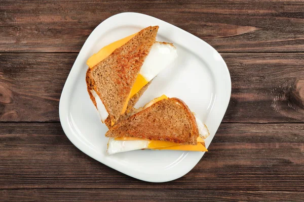 Delicious sandwiches with over easy egg and cheese on kitchen table — Stock Photo, Image